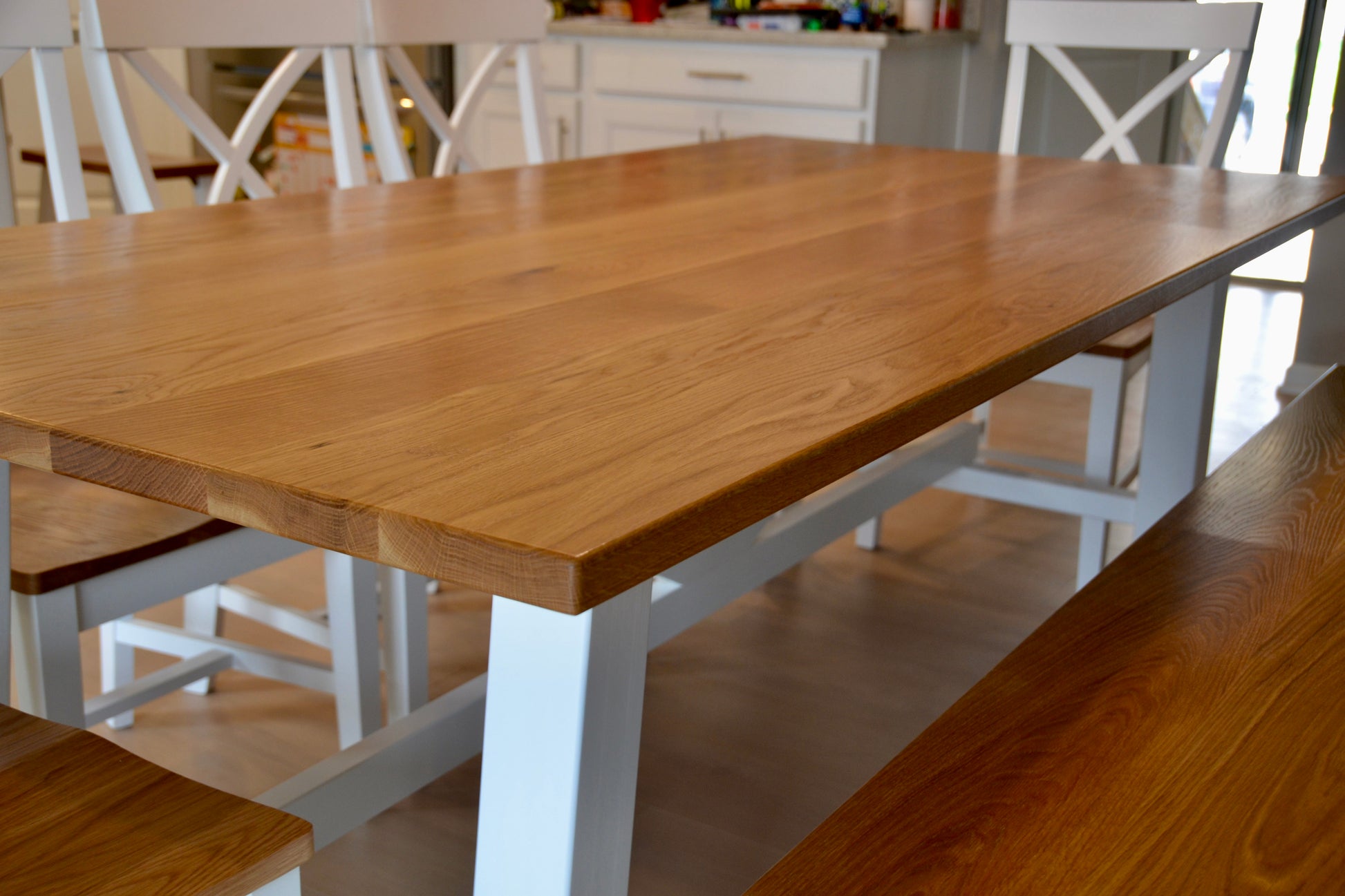 Wooden dining table with white legs in a kitchen setting